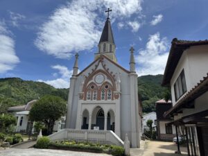 Tsuwano Catholic Church set against a blue sky and forested hills behind