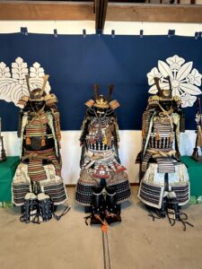 three samurai suits with a navy background
