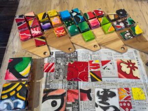 Colourful tiles on block of wood - small squares laid out on table