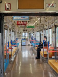 Empty train carraiage with man sitting alone on left